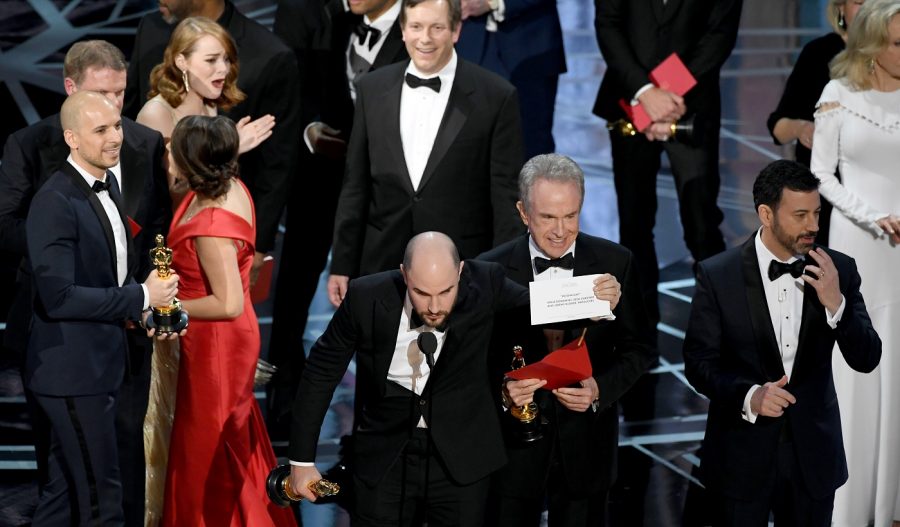 HOLLYWOOD, CA - FEBRUARY 26:  (L-R) 'La La Land' producer Jordan Horowitz holds up the winner card reading actual Best Picture winner 'Moonlight' with actor Warren Beatty and host Jimmy Kimmel onstage during the 89th Annual Academy Awards at Hollywood &amp; Highland Center on February 26, 2017 in Hollywood, California.  (Photo by Kevin Winter/Getty Images)