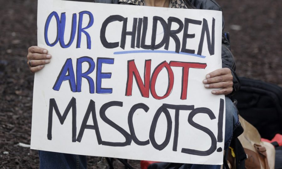 Jerald Beckman holds up a sign in protest of the use of Chief Wahoo by the Cleveland  Indians before a baseball game between the Minnesota Twins and the Cleveland Indians, Friday, April 4, 2014, in Cleveland. (AP Photo/Tony Dejak) ORG XMIT: OHTD101