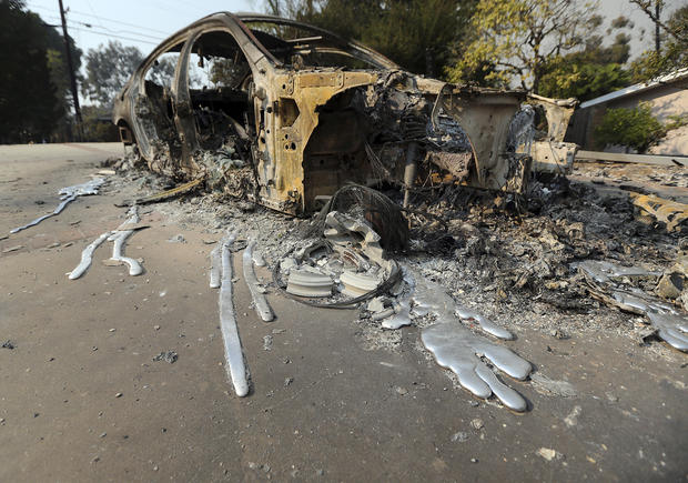 Molten aluminum has flowed from a car that burned in front of one of at least 20 homes destroyed just on Windermere Drive in the Point Dume area of Malibu, Calif., Saturday, Nov. 10, 2018. Known as the Woolsey Fire, it has consumed thousands of acres and destroyed dozens of homes. (AP Photo/Reed Saxon)